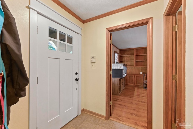 entryway with crown molding, a textured ceiling, light hardwood / wood-style flooring, and a wealth of natural light