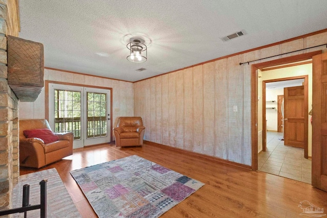 unfurnished room with crown molding, a textured ceiling, and wood-type flooring