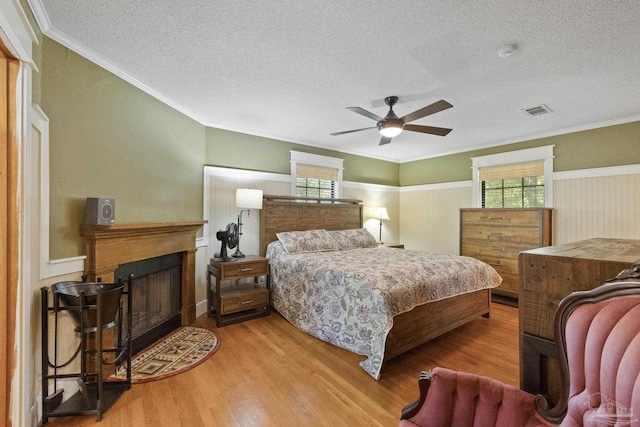 bedroom featuring a textured ceiling, multiple windows, and wood finished floors