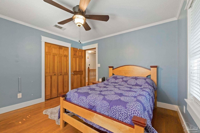 bedroom featuring ornamental molding, wood-type flooring, a closet, and ceiling fan