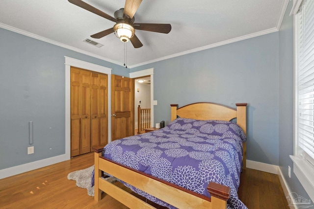 bedroom featuring baseboards, visible vents, and wood finished floors
