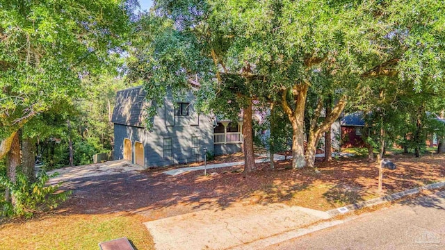 obstructed view of property with driveway and a garage