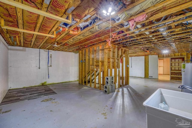 below grade area with water heater and a sink