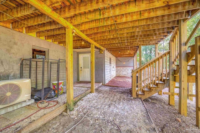 interior space with stairway, an exterior structure, and ac unit