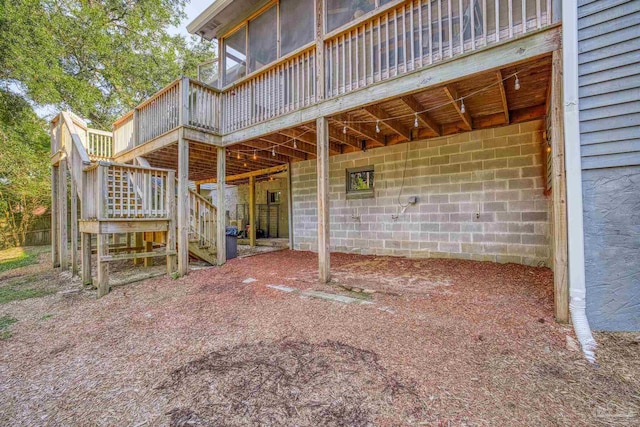 exterior space with stairs, a wooden deck, and a sunroom