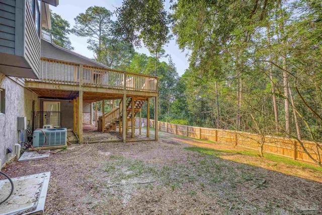 view of yard with central AC, a wooden deck, a fenced backyard, and stairs
