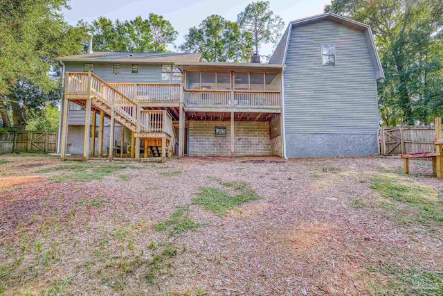 rear view of property featuring a deck and a sunroom