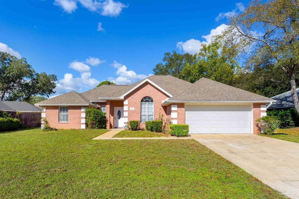 ranch-style house featuring a front yard and a garage