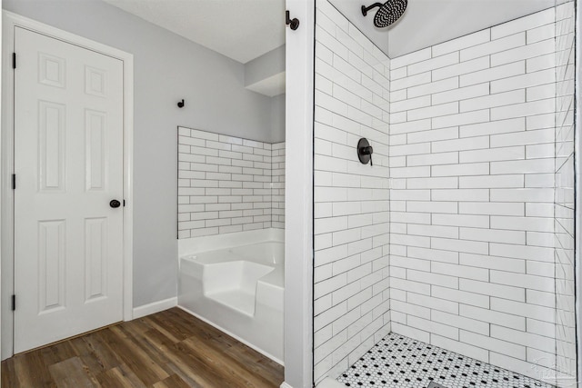 bathroom featuring hardwood / wood-style floors and tiled shower