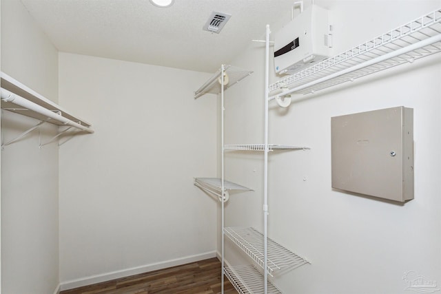 walk in closet with dark wood-type flooring