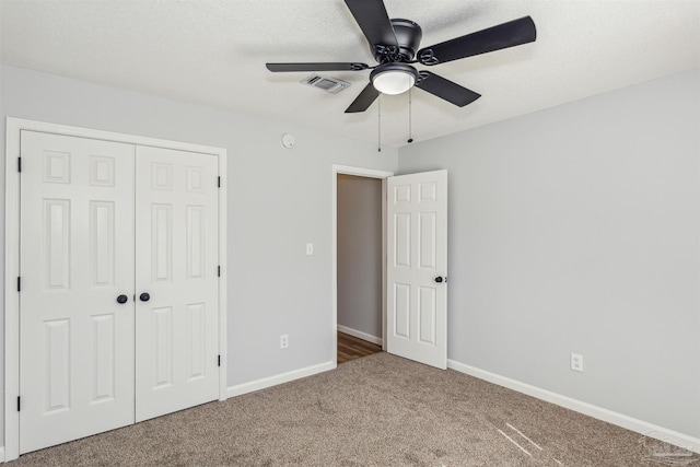 unfurnished bedroom featuring a closet, a textured ceiling, carpet flooring, and ceiling fan