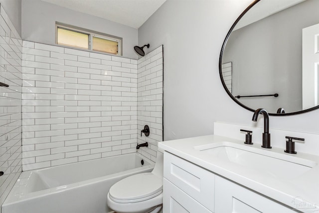 full bathroom with vanity, tiled shower / bath, toilet, and a textured ceiling