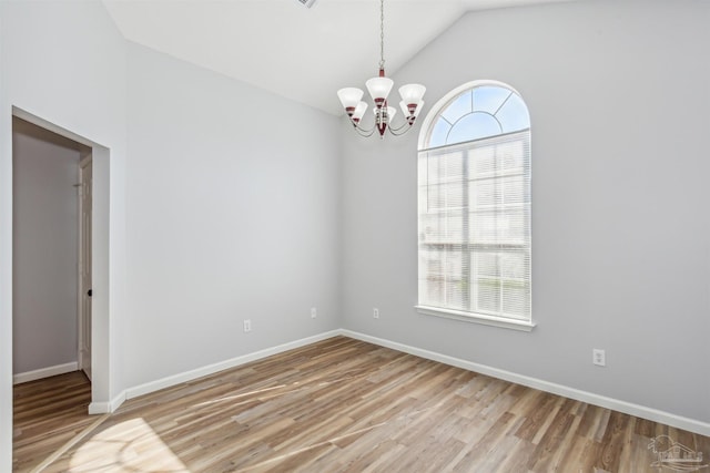 spare room with light hardwood / wood-style floors, lofted ceiling, and a notable chandelier