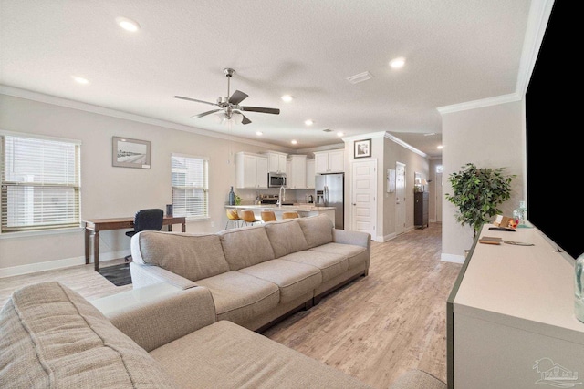 living room with a textured ceiling, ceiling fan, light wood-type flooring, and ornamental molding