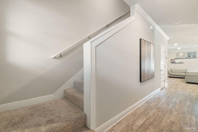 stairway with hardwood / wood-style floors and crown molding