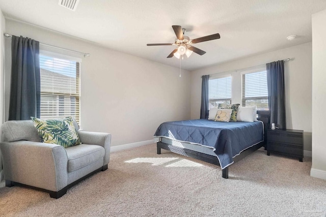 carpeted bedroom with multiple windows and ceiling fan