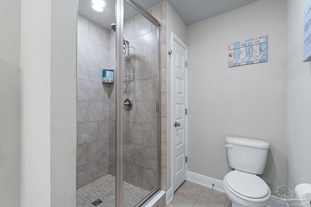 bathroom featuring tile patterned flooring, toilet, and walk in shower