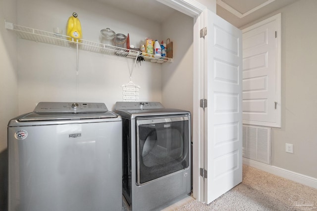 clothes washing area featuring light colored carpet and washing machine and clothes dryer