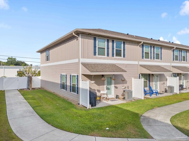 rear view of house with a patio, central AC, and a lawn