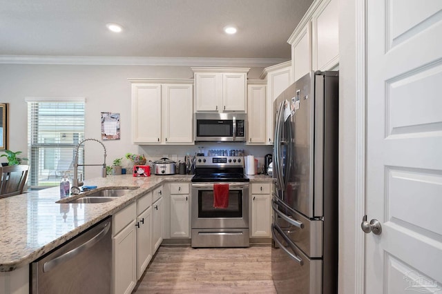 kitchen featuring sink, stainless steel appliances, crown molding, light hardwood / wood-style floors, and white cabinets