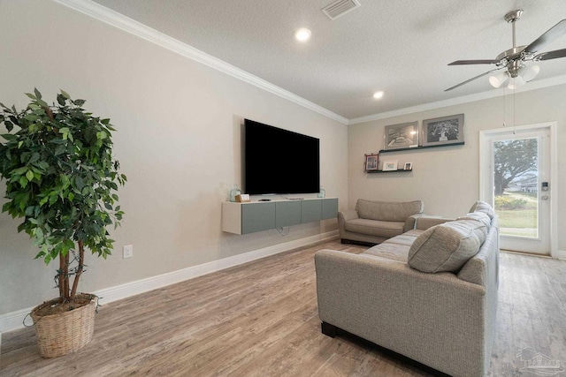 living room featuring a textured ceiling, light hardwood / wood-style flooring, ceiling fan, and crown molding