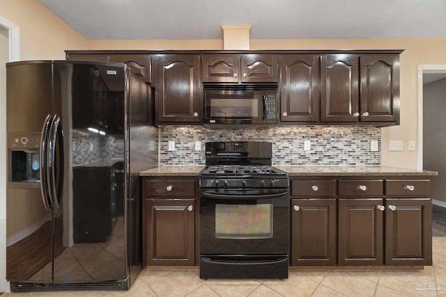 kitchen featuring dark brown cabinetry, black appliances, tasteful backsplash, and light stone counters