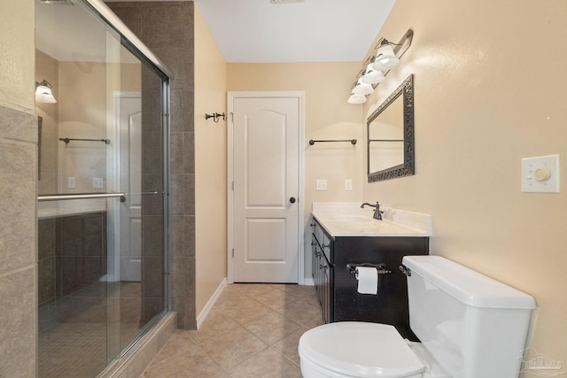 bathroom featuring toilet, vanity, tile patterned floors, and a shower with door