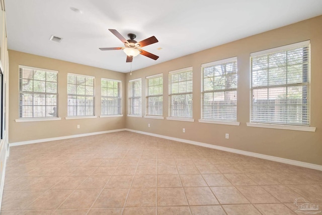 tiled spare room with ceiling fan and plenty of natural light