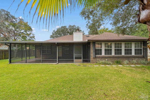 back of property with a yard and a sunroom