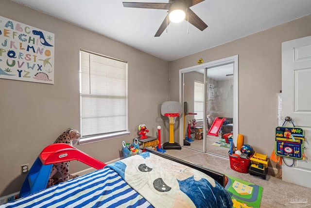 carpeted bedroom with ceiling fan and a closet