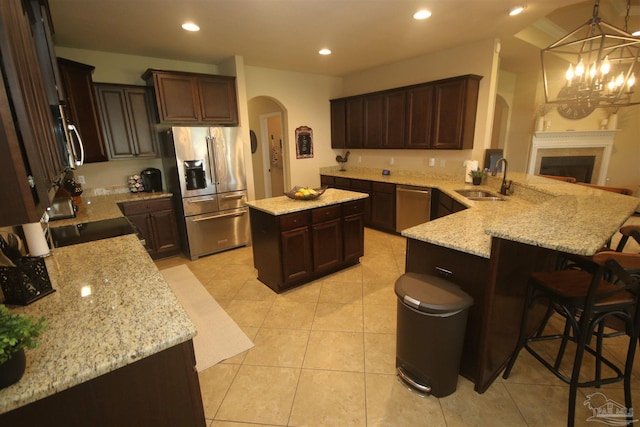 4135 Dundee Crossing Dr, Pace, FL 32571 - kitchen with stainless steel appliances, arched walkways, a sink, a peninsula, and light stone counters