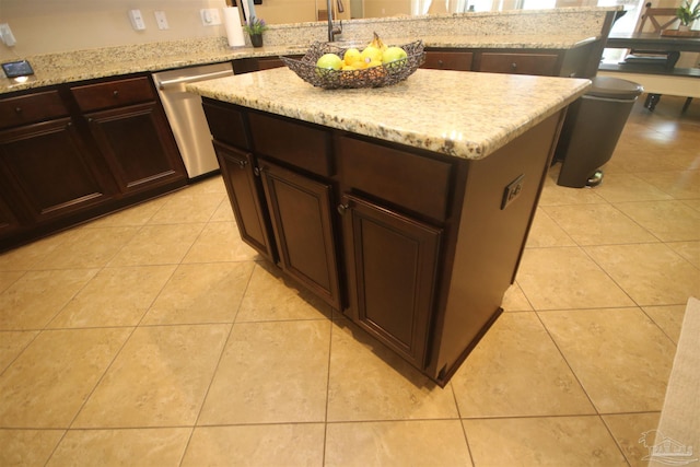 4135 Dundee Crossing Dr, Pace, FL 32571 - kitchen with dishwasher, a kitchen island, light tile patterned floors, light stone countertops, and dark brown cabinetry