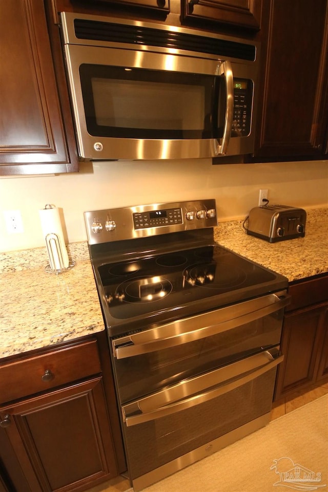 4135 Dundee Crossing Dr, Pace, FL 32571 - kitchen featuring appliances with stainless steel finishes, light stone countertops, and dark brown cabinets