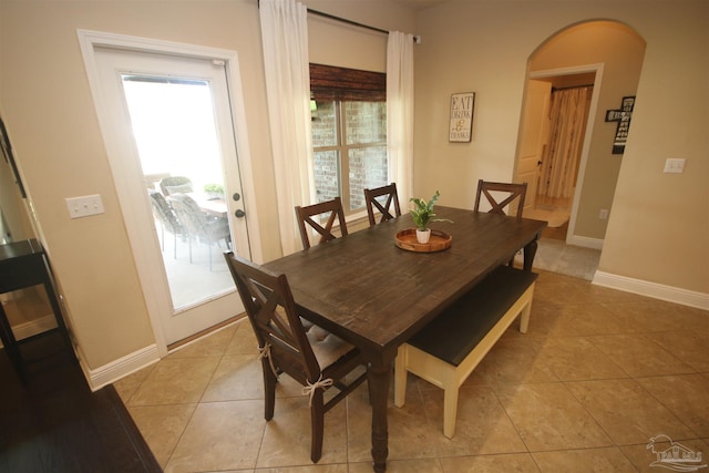 4135 Dundee Crossing Dr, Pace, FL 32571 - dining room with light tile patterned floors, arched walkways, and baseboards