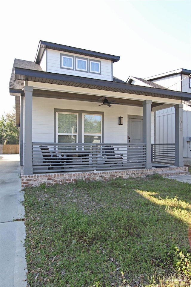 view of front of property featuring ceiling fan, covered porch, and a front yard