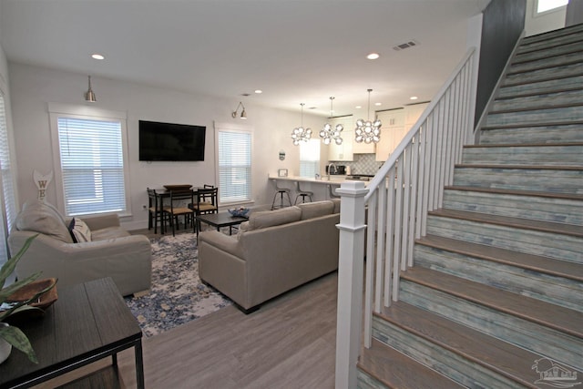 living room featuring light hardwood / wood-style flooring and an inviting chandelier