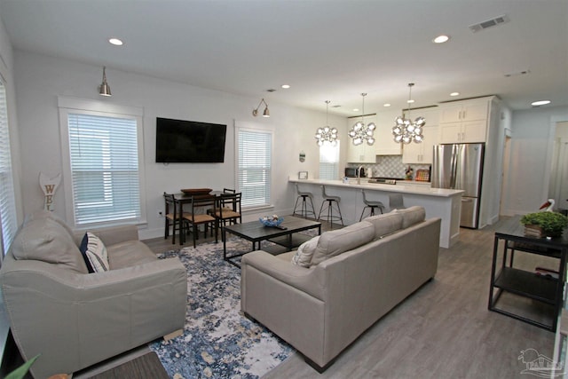 living room featuring a notable chandelier and light hardwood / wood-style flooring