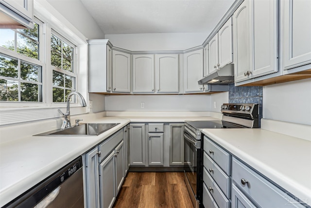 808 Woodland Dr, Pensacola, FL 32503 - kitchen with stainless steel appliances, a sink, dark wood-style flooring, gray cabinetry, and under cabinet range hood