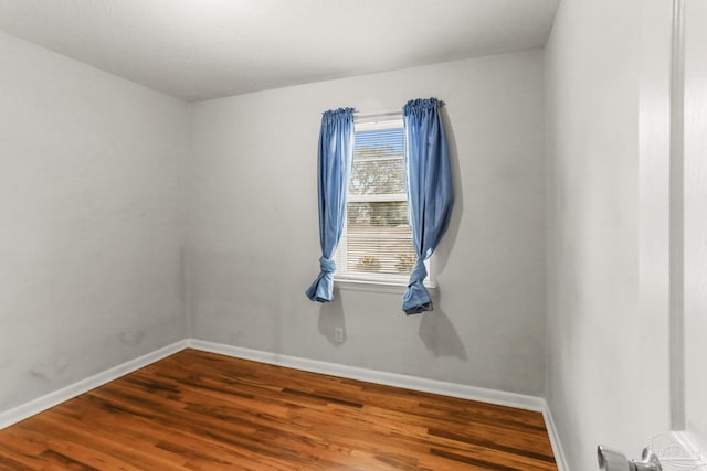 unfurnished room featuring wood finished floors and baseboards