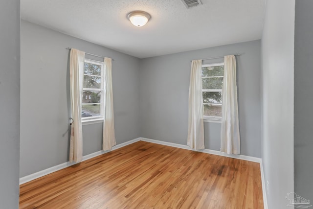 spare room featuring light wood-type flooring and baseboards