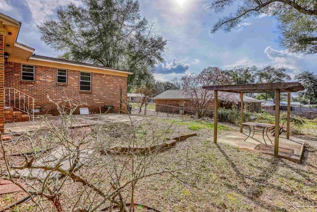 view of yard with a patio area, fence, and a pergola