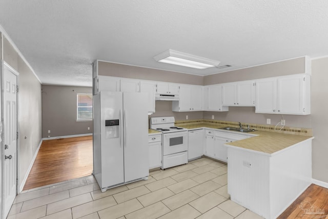 kitchen featuring light countertops, white cabinets, a peninsula, white appliances, and under cabinet range hood