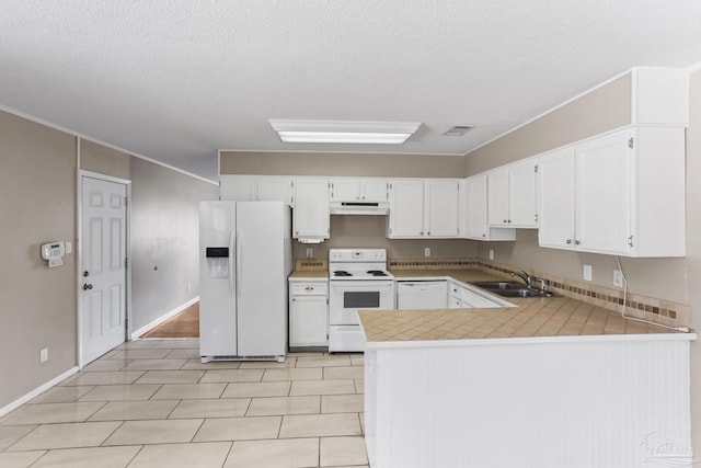 kitchen featuring under cabinet range hood, a peninsula, white appliances, a sink, and white cabinetry