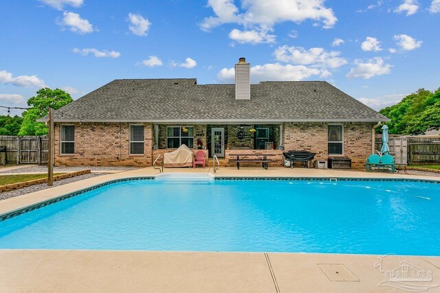 view of swimming pool featuring fence and a patio area