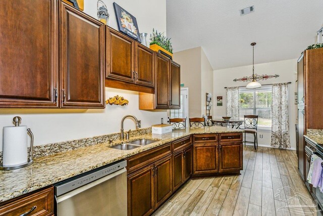kitchen with dishwasher, a sink, light wood-type flooring, pendant lighting, and light stone counters