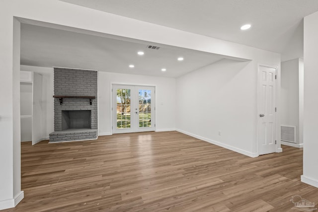 unfurnished living room with visible vents, baseboards, and wood finished floors