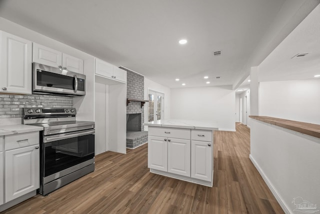 kitchen featuring white cabinetry, stainless steel appliances, and wood finished floors