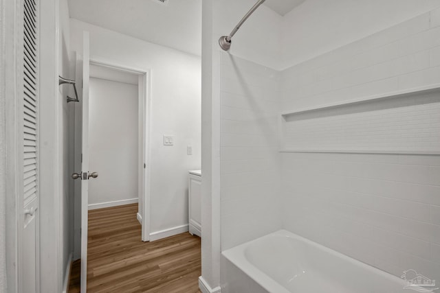 bathroom featuring shower / bathing tub combination, wood finished floors, and baseboards