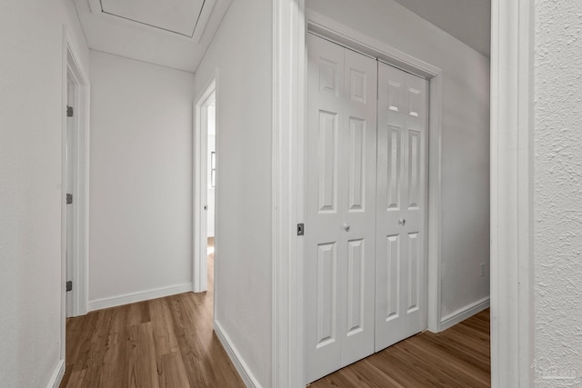 hallway featuring wood finished floors and baseboards