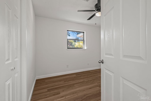 unfurnished bedroom with wood finished floors, a ceiling fan, and baseboards